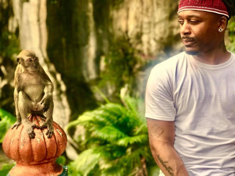 a man sits with a monkey
