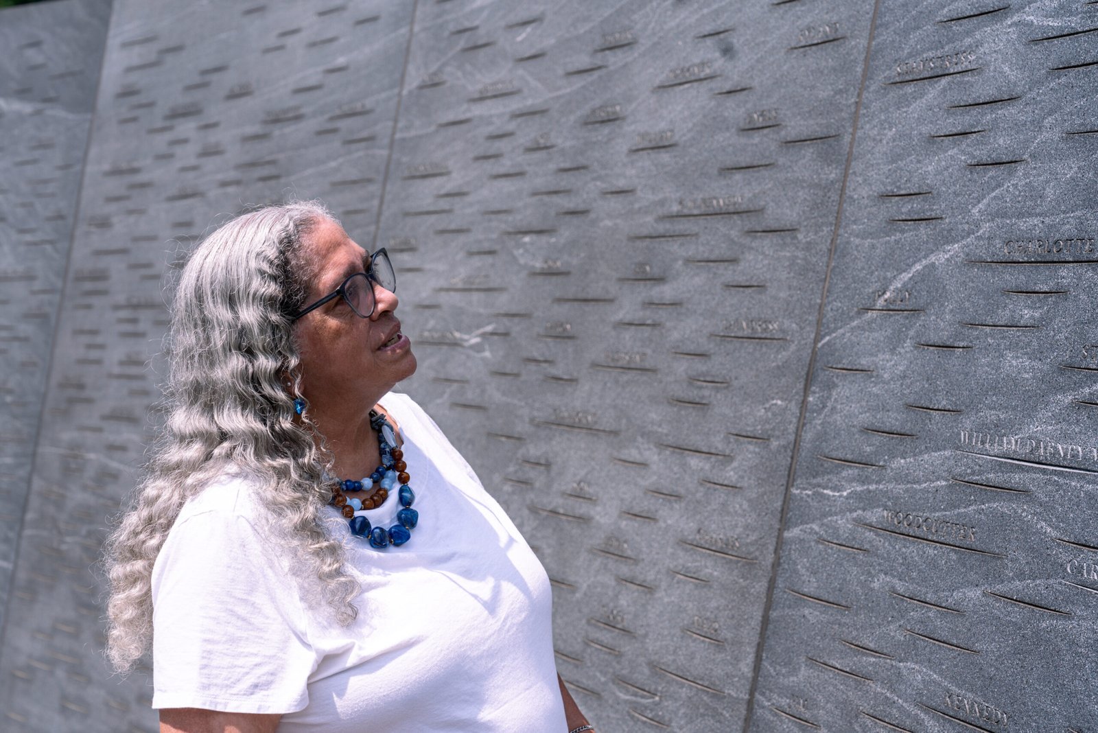 a woman stands beside a monument